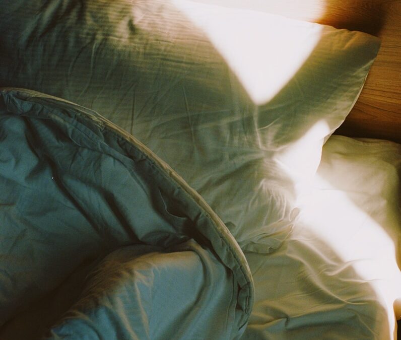 a bed with a white comforter and a wooden head board